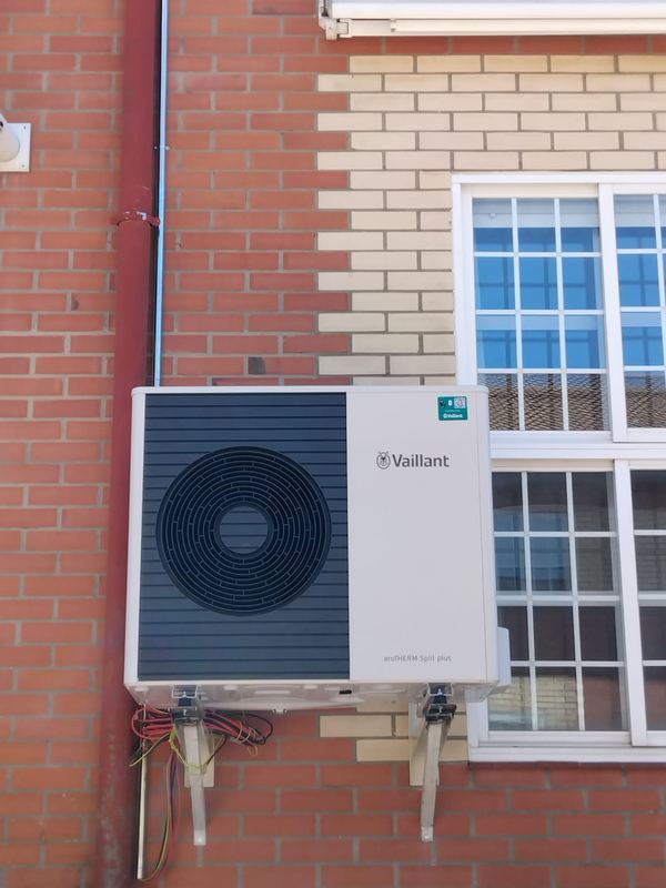 Bomba de calor de aerotermia Vaillant instalada en la fachada de una vivienda en Madrid Norte
