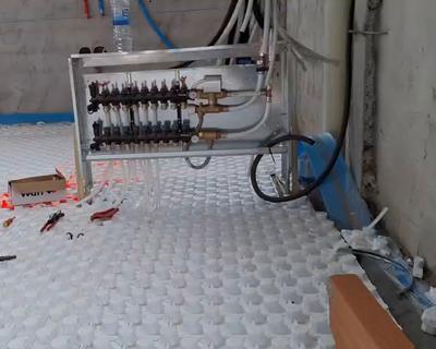 Colector y tubos del suelo radiante y refrescante sobre el panel aislante en una obra de 700 m² en Madrid