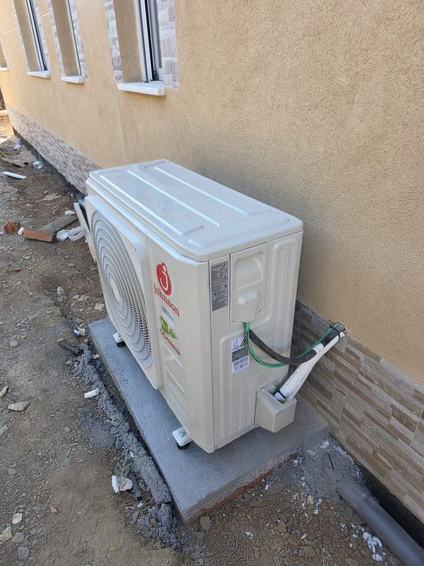 Unidad exterior de aire acondicionado por conductos instalada sobre bancada en una vivienda de Soto del Real (Madrid)