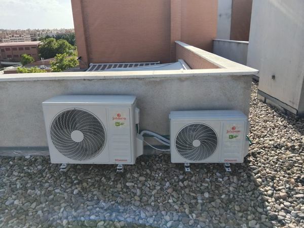 Dos unidades exteriores de aire acondicionado instaladas sobre grava en una azotea
