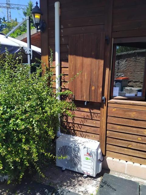 Unidad exterior de aire acondicionado instalada en el jardín de una vivienda en Madrid Norte