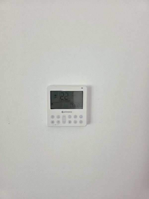 Termostato de pared Johnson marcando 22 grados